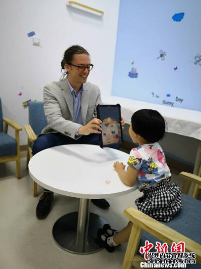 英国专家用AI猴与孩子开心互动。　陈静 摄