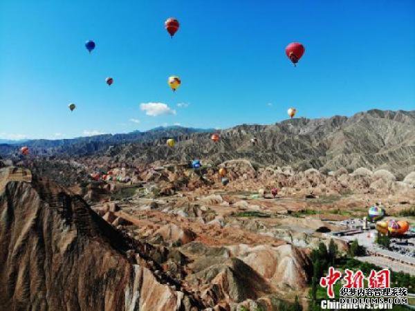 甘肃张掖七彩丹霞“牵手”热气球 游客众览“彩虹山”