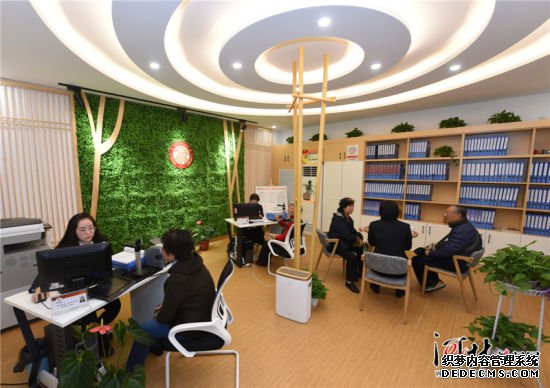 　11月5日，在石家庄市新华区革新街道天骄社区“居家式会客厅”内，工作人员为居民办理业务。 　　天骄社区居委会经过改造，形成了多功能融合的社区共享空间，社区工作人员可以在一个窗口受理救济、社保、计生等各项业务，为居民提供综合服务。 记者史晟全摄影报道