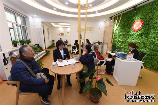 11月5日，在石家庄市新华区革新街道天骄社区“居家式会客厅”内，工作人员为居民办理业务。 　　天骄社区居委会经过改造，形成了多功能融合的社区共享空间，社区工作人员可以在一个窗口受理救济、社保、计生等各项业务，为居民提供综合服务。 记者史晟全摄影报道