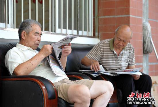 资料图：武汉洪山区通惠社区养老院安置点，2位老人悠闲地看着报纸。 /p中新社记者 张畅 摄