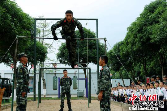 官兵向“萌娃”们表演器械训练。　王彬 摄