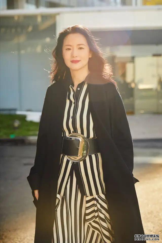 咏梅黑白条纹裙装搭配黑色大衣，优雅又大方，散发成熟魅力