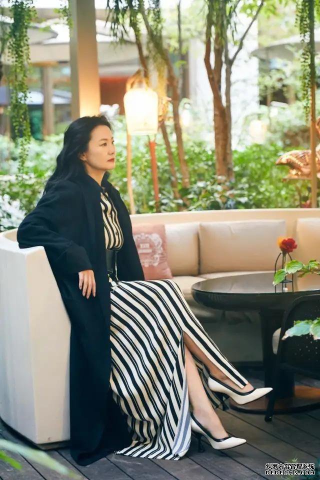 咏梅黑白条纹裙装搭配黑色大衣，优雅又大方，散发成熟魅力